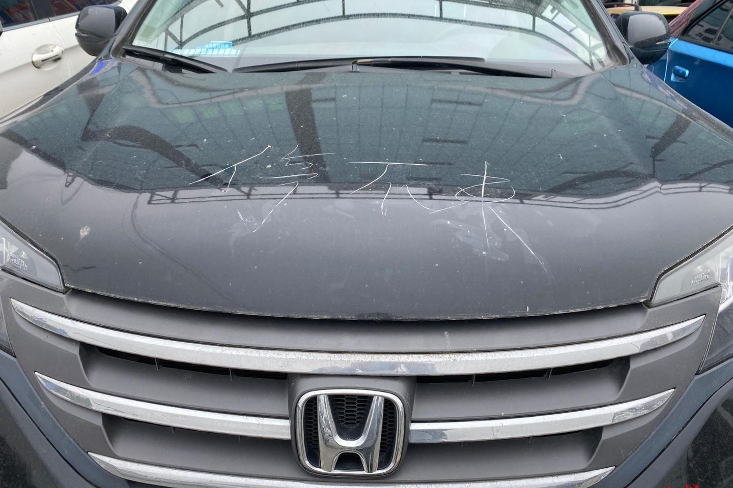 女司机停车压线 疑似被人用砖头在车头刻字“停不来”，警方已立案调查