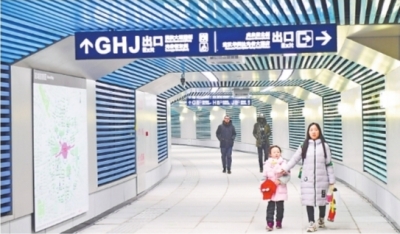 通道内蓝、绿色的栅栏状墙面装饰间隔分布，步行其中，犹如走入时光隧道