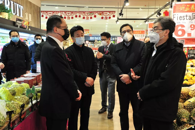 在永旺超市,振华商厦超市,牟树青在听取负责人关于疫情防控及保供稳价