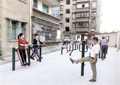 在潜江市摩托车厂小区，居民们使用新建的健身设施。