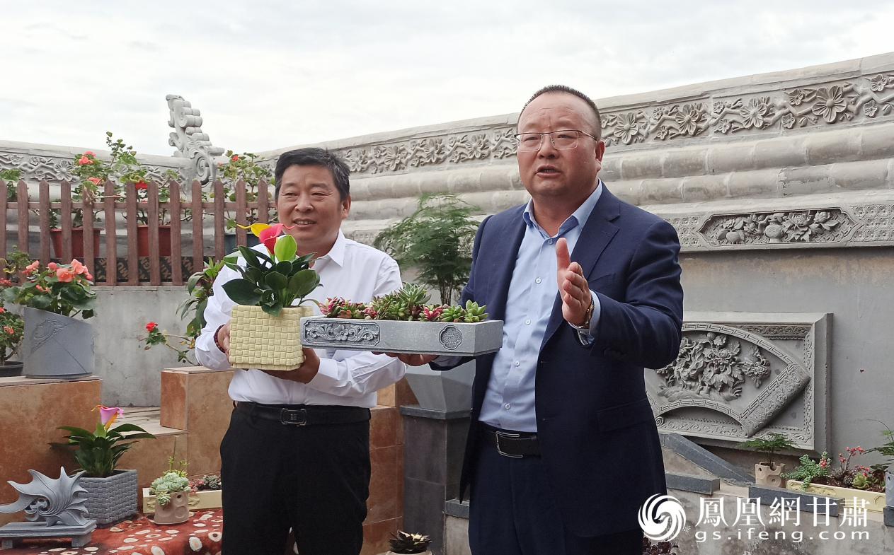 管兰生（左一）与临夏能成古典建筑装饰工程有限责任公司总经理成小娇（右一）介绍砖雕艺术文创产品 张勇 摄