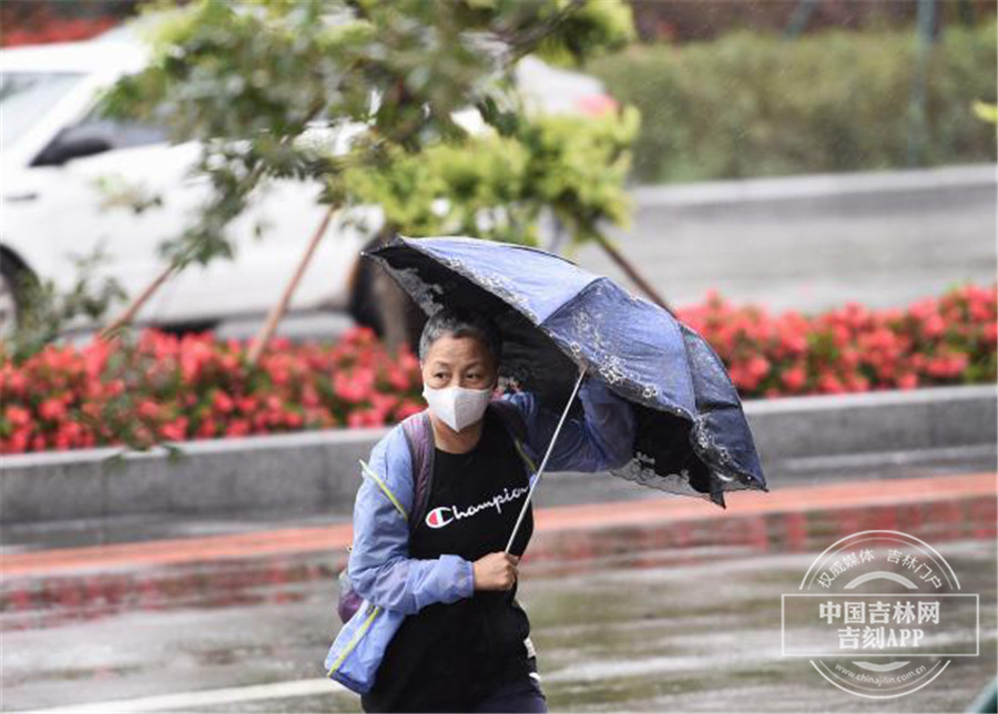受台风影响 长春市民在风雨中出行