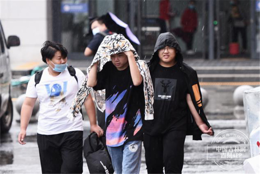 受台风影响 长春市民在风雨中出行
