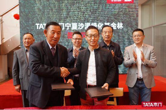 tata木门董事长纵瑞原(右)与"人民楷模"王有德(左)签约后握手