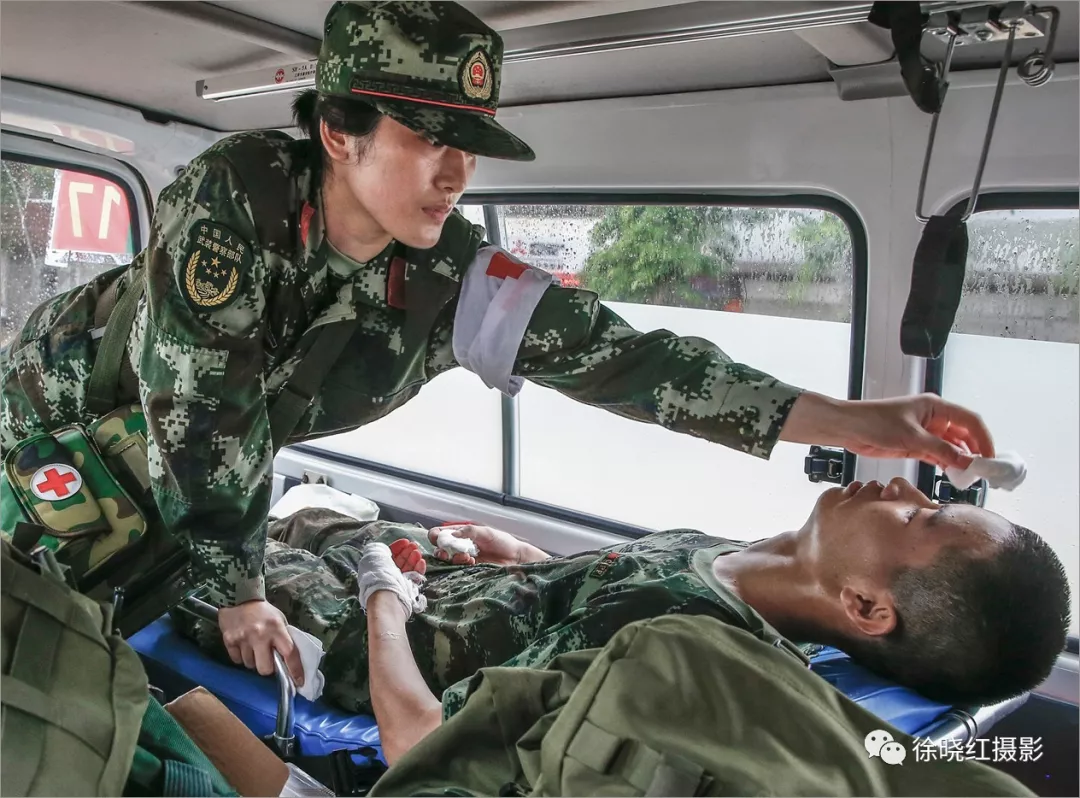一名武警战士在抢险中受伤,卫生员为他做简单包扎.