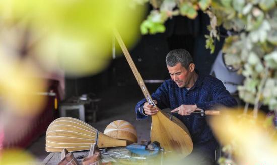 村民阿布都克热穆·吐尔逊在家中院落制作民族乐器