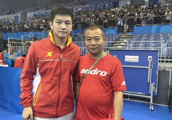 去年世乒赛团体赛出发前,王涛冒雨为樊振东送行并作最后叮咛指导.