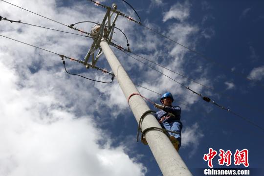 图为青海玉树隆宝国家级自然保护区内正在巡线的电力工人。　罗云鹏摄