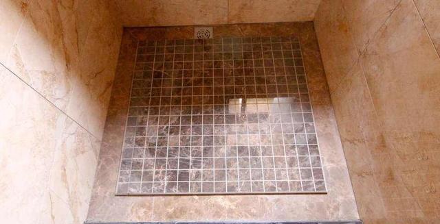 当然为了让淋浴房更具防滑,除了导水槽,我们还可以把中间凸起的地面做