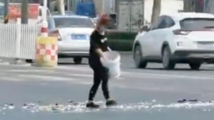 女子马路中央摔酒瓶、抛垃圾 警方：有精神疾病