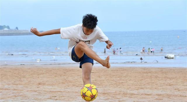 这是7月16日"长风"足球队球员陈孝鸿在沙滩上练球.
