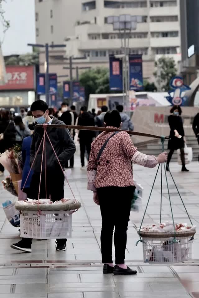 本组图:王奉琳 摄 马路边,空地上 流动商贩和棒棒的吆喝声中 蕴藏着