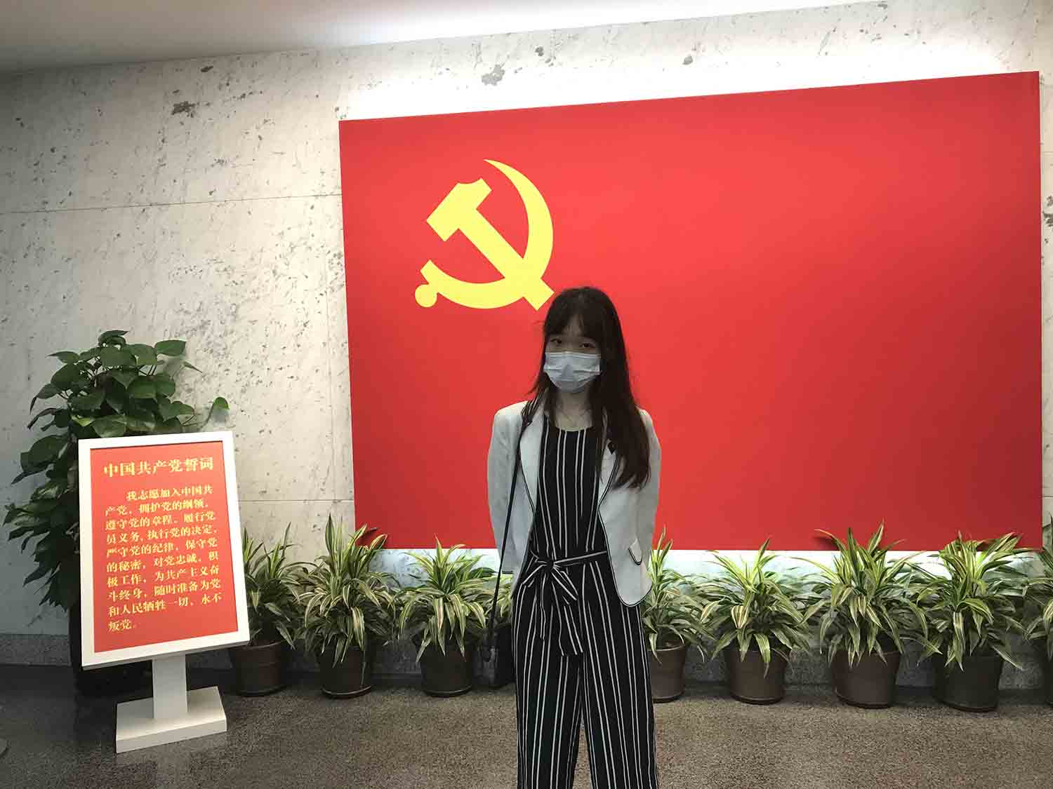 高考结束的李玮宜在一大会址的党旗前拍照留念 受访者供图