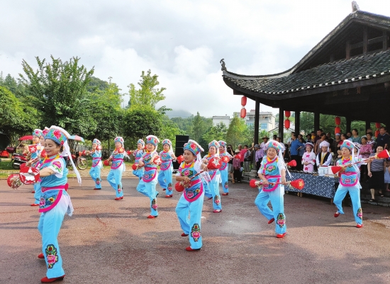 8月12日,桑植县洪家关白族乡,当地村民身穿民族服装在贺龙桥前跳仗