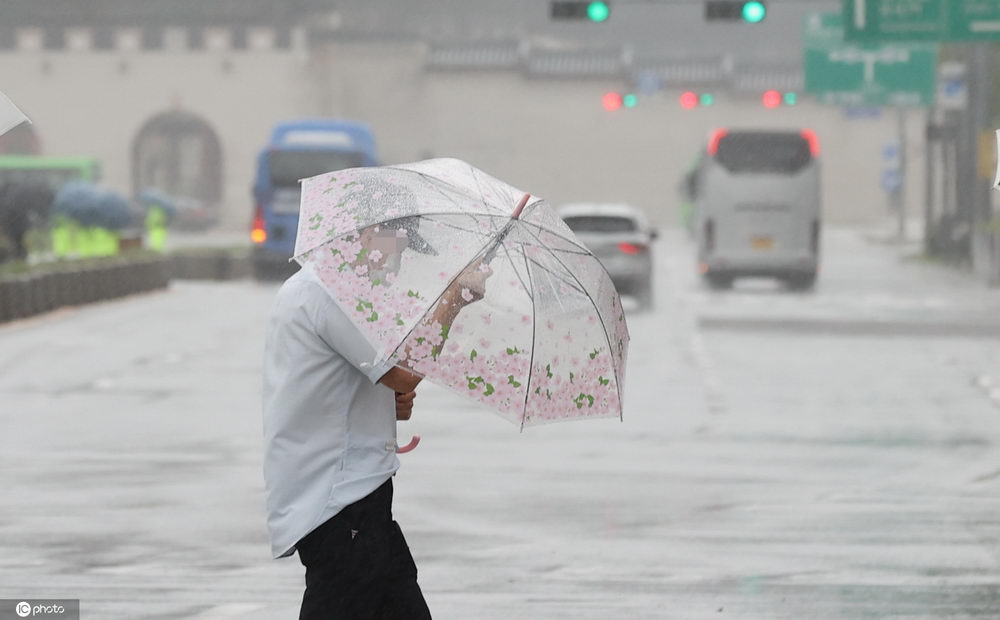 超强台风"巴威"影响韩国风雨交加民众冒雨出行