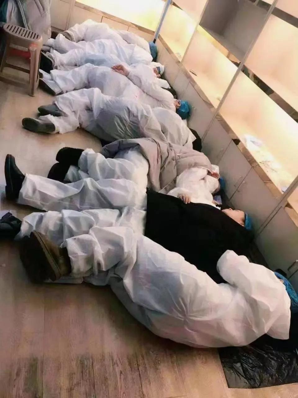 一排蜷缩在地,只为与疫情战斗到底 没有床 没有座椅 他们连身上的