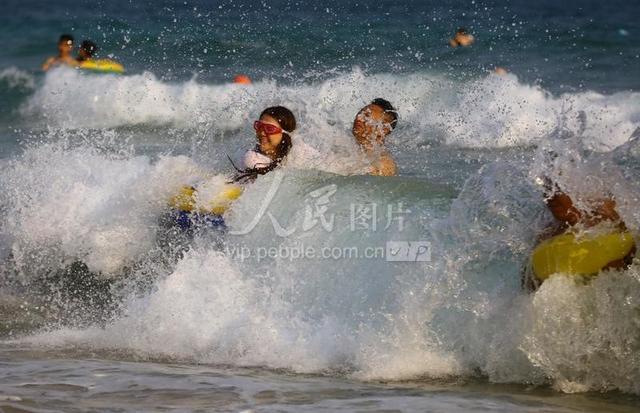 2020年4月20日,海南三亚,游客在三亚市大东海景区海边戏水.
