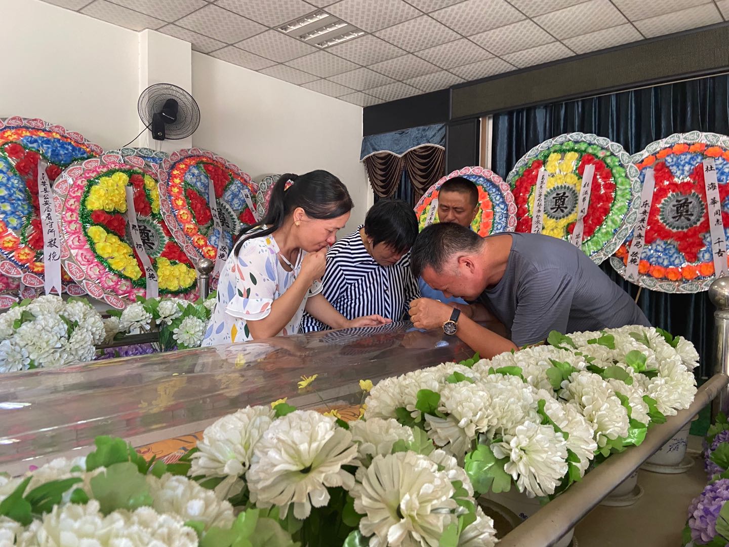 8月16日上午，在乐安县殡仪馆，趴在棺上失声痛哭的杜海华父母及其亲属。澎湃新闻 图