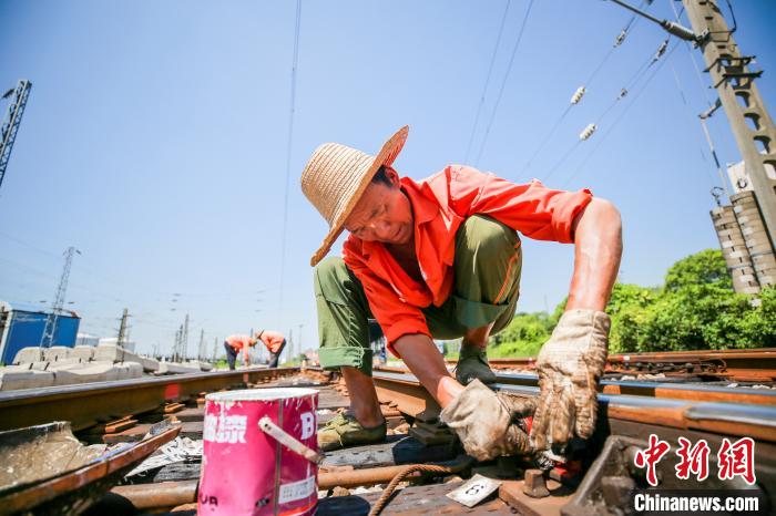7月22日,铁路工人在高温环境下刷油漆标志 盛德权 摄