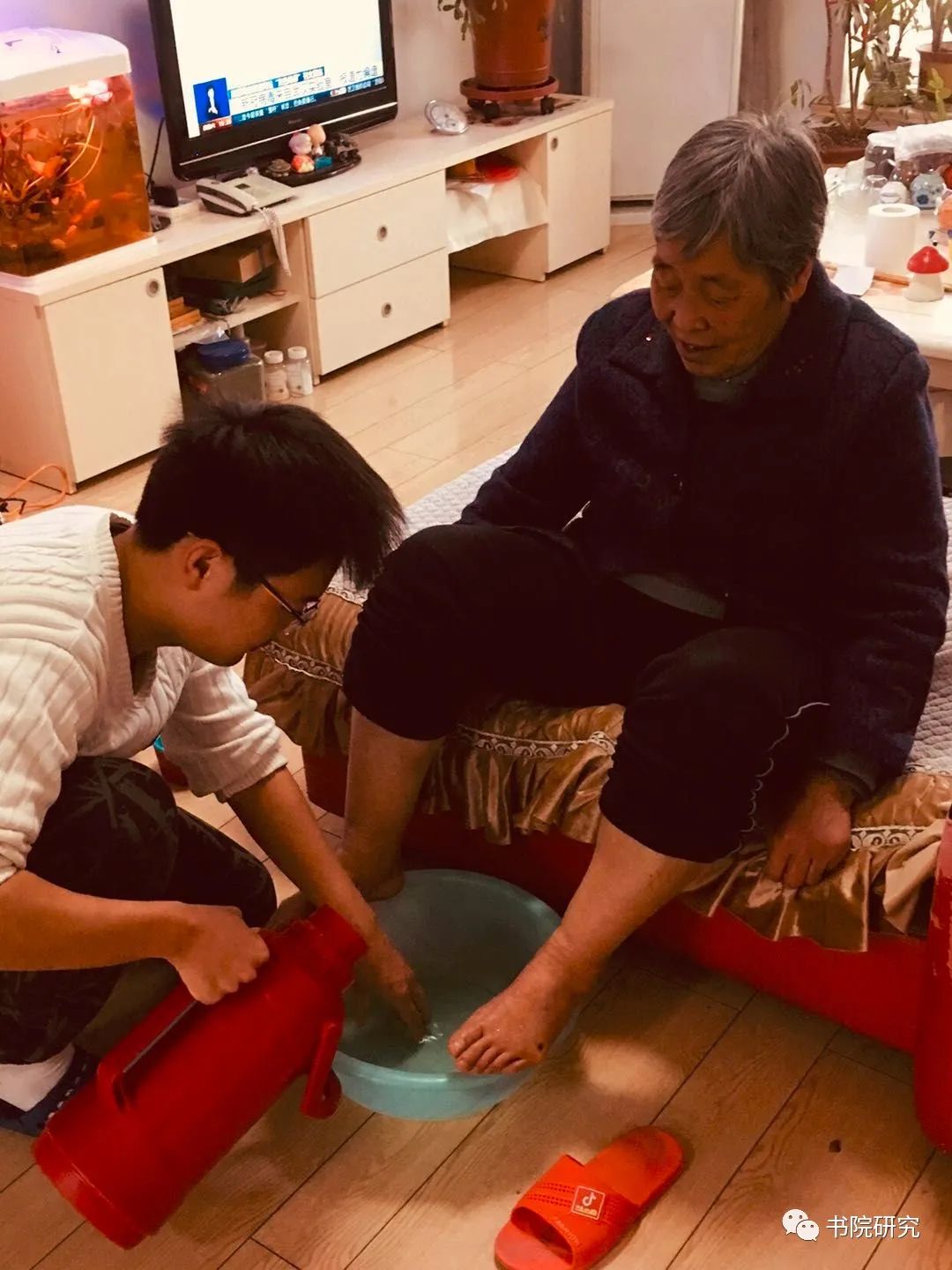 申昊宇同学在帮奶奶准备洗脚水,用手试试水温是否合适