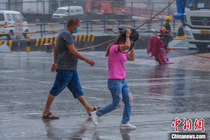 图为在雨中奔跑的过海旅客. 骆云飞 摄