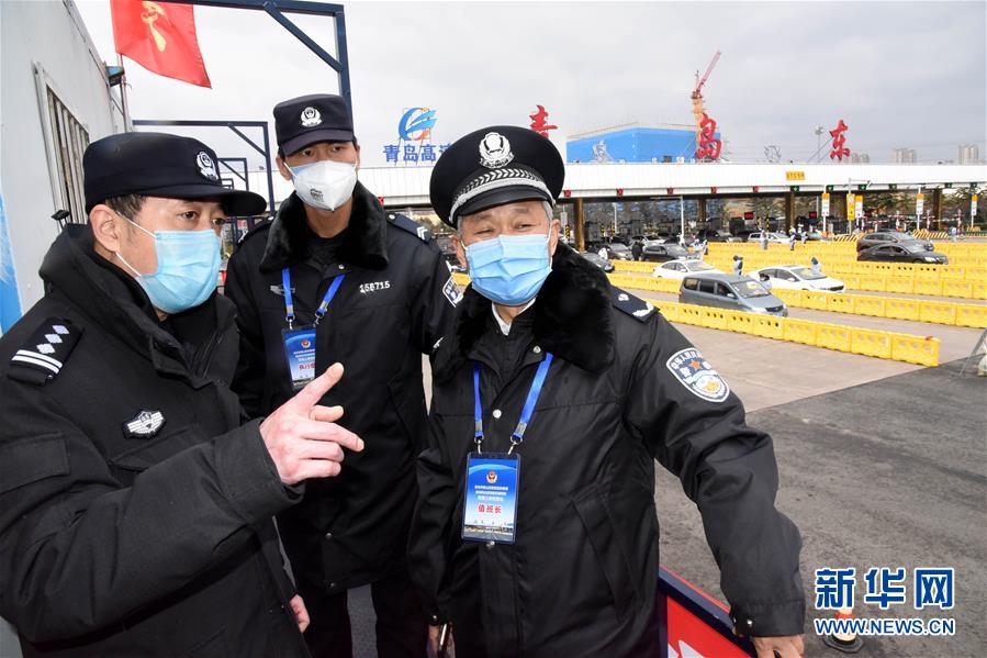 2月25日,朱志谦(右一)与干警在青银高速青岛东疫情检查站值守.