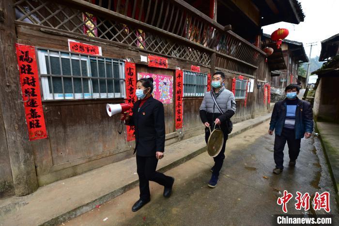 图为2月5日,罗光珍(中)和村医对村民进行体温测量 杨武魁 摄