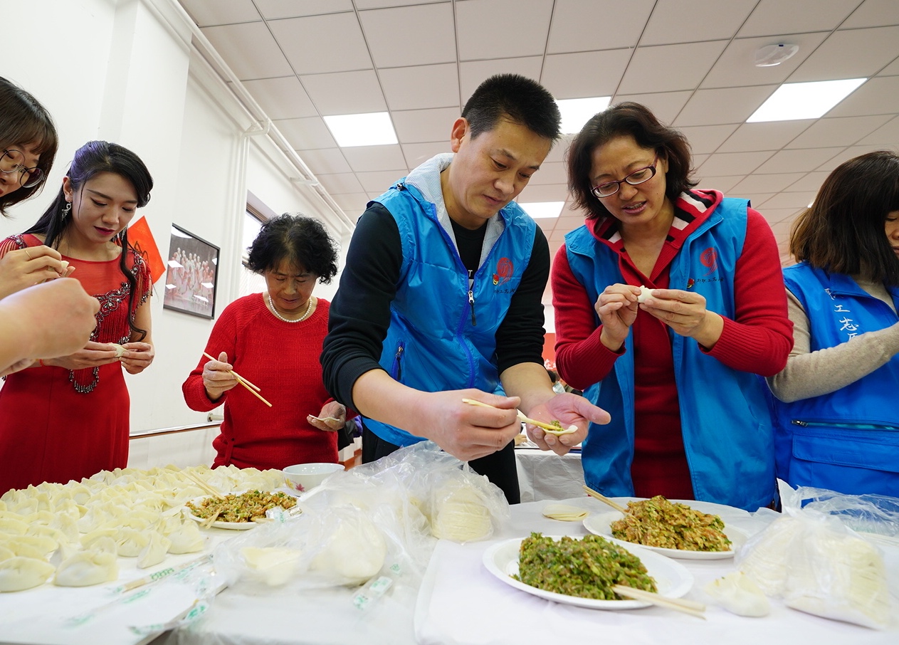 社区居民志愿者和外来务工人员一起包饺子.