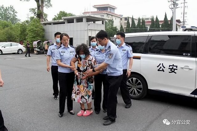 戴着手铐脚镣的 犯罪嫌疑人袁某被押下警车