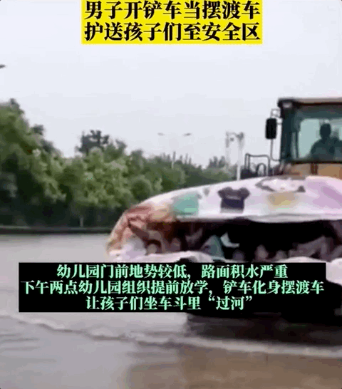 铲车师傅让孩子们坐在车斗里,载他们"过河".