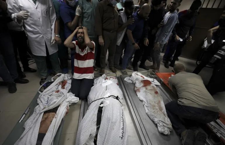 面对家人的尸体,一名巴勒斯坦人抱头痛哭. 来源:半岛电视台