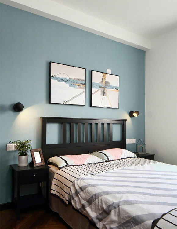 次卧室的装修效果,蓝灰色乳胶漆床头背景墙,黑色的实木床架,看起来