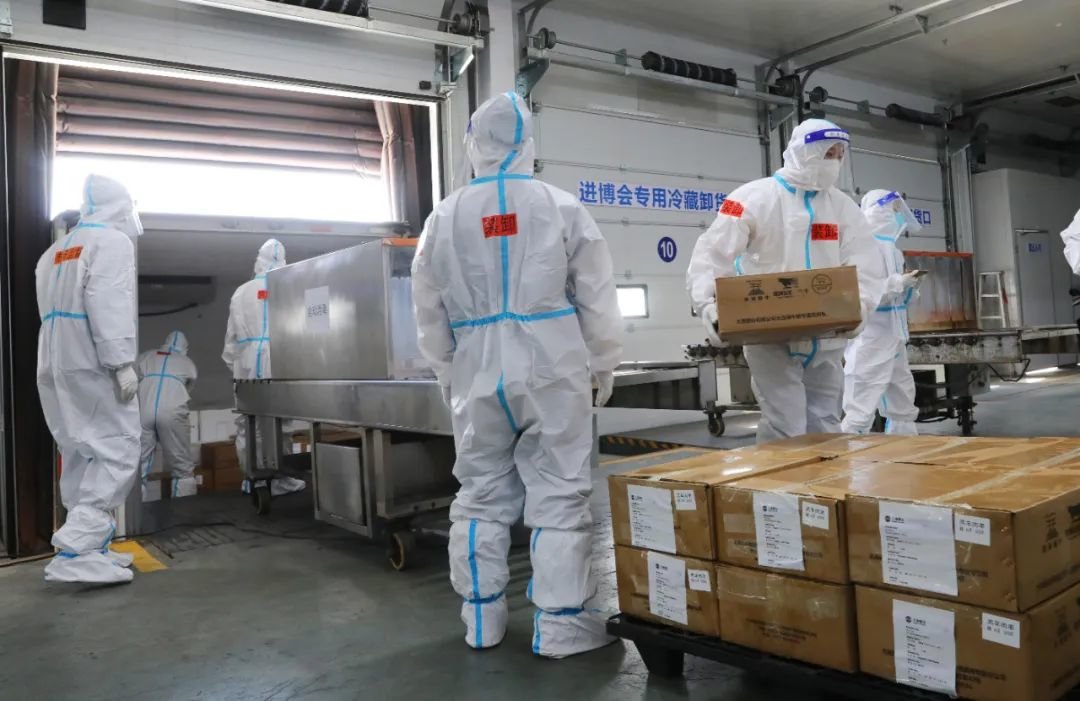 10月20日,第五届进博会首单冷链食品展品抵沪入仓,工作人员在总仓内搬运完成卸车消毒的冷链食品展品。图源:新华社