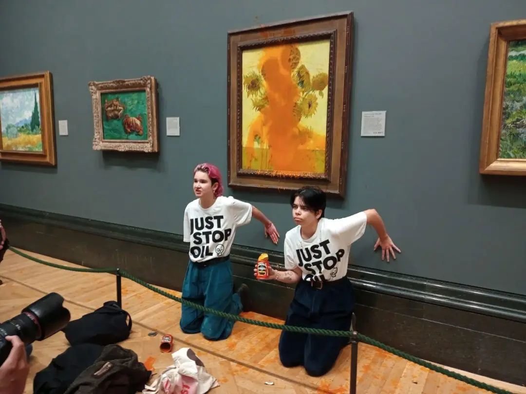 10月14日，英国国家美术馆内，两名环保组织“请停止石油开发”抗议者向梵高1888年的画作《向日葵》泼洒番茄汤。图/IC photo