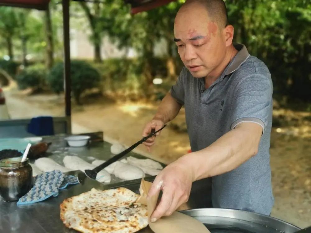 4月20日,曹加齐正在烤制烧饼.王力中摄