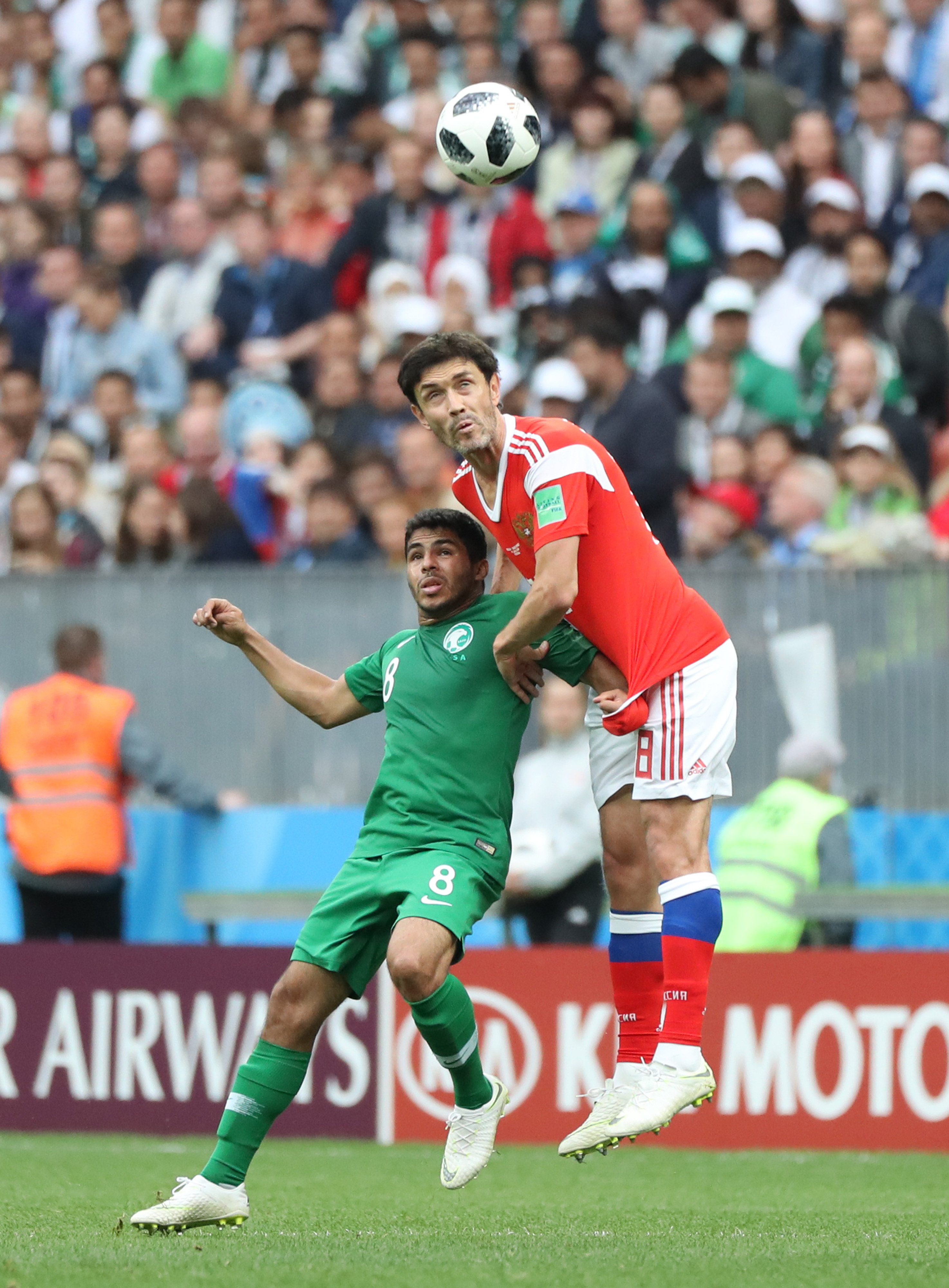 2018年6月14日，沙特阿拉伯队球员谢赫里（左）与俄罗斯队球员加辛斯基在俄罗斯世界杯比赛中拼抢。