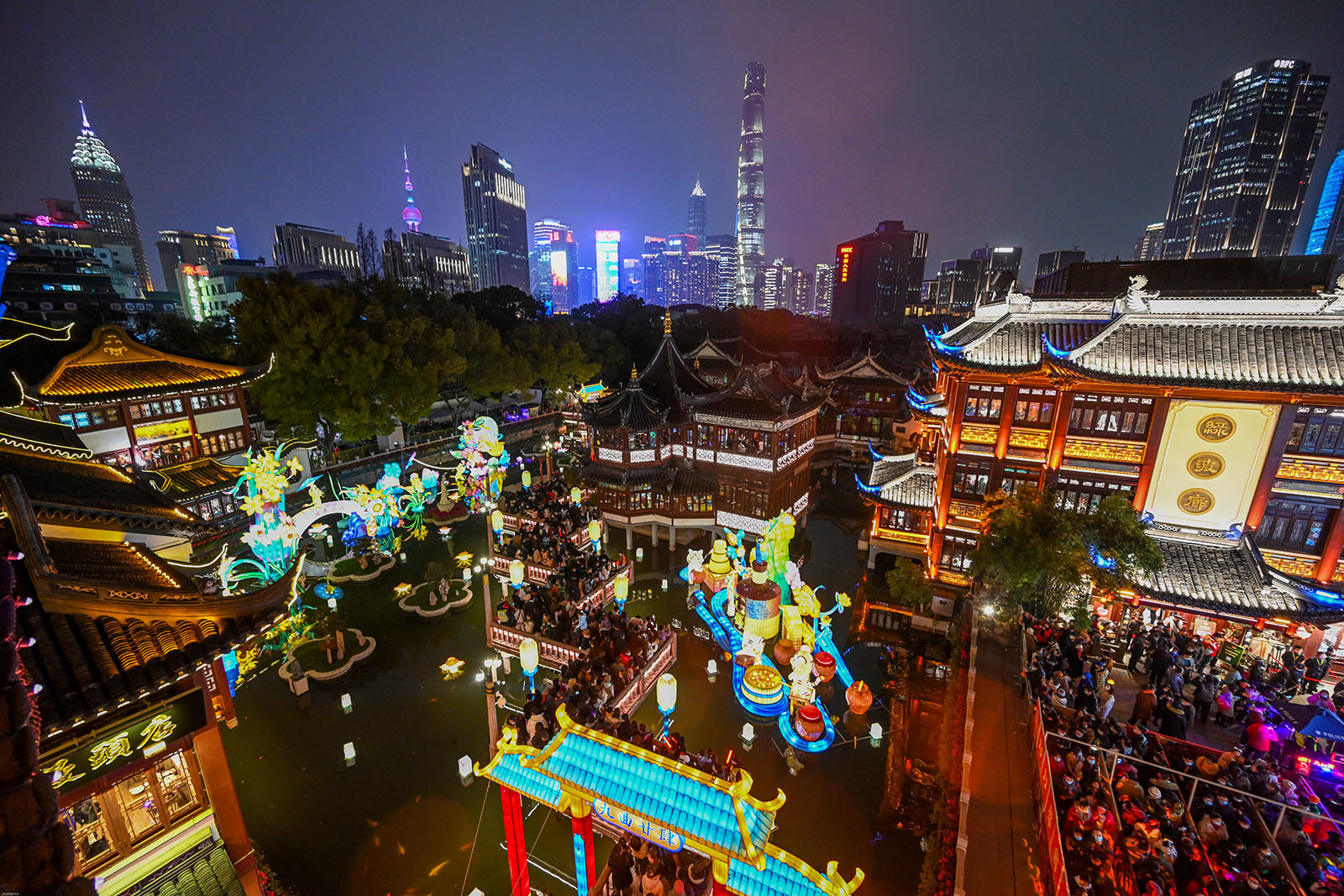 2022年2月14日,上海豫园,九曲桥上璀璨的灯光和远处上海地标建筑交相