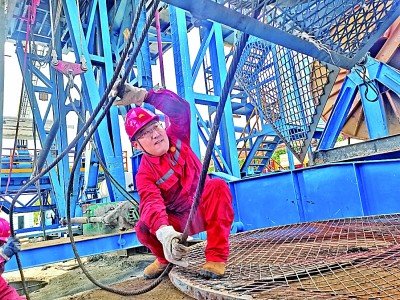 张晶在安装井架。光明图片