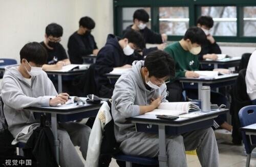 韩国学生在教室内戴口罩看书。（资料图）