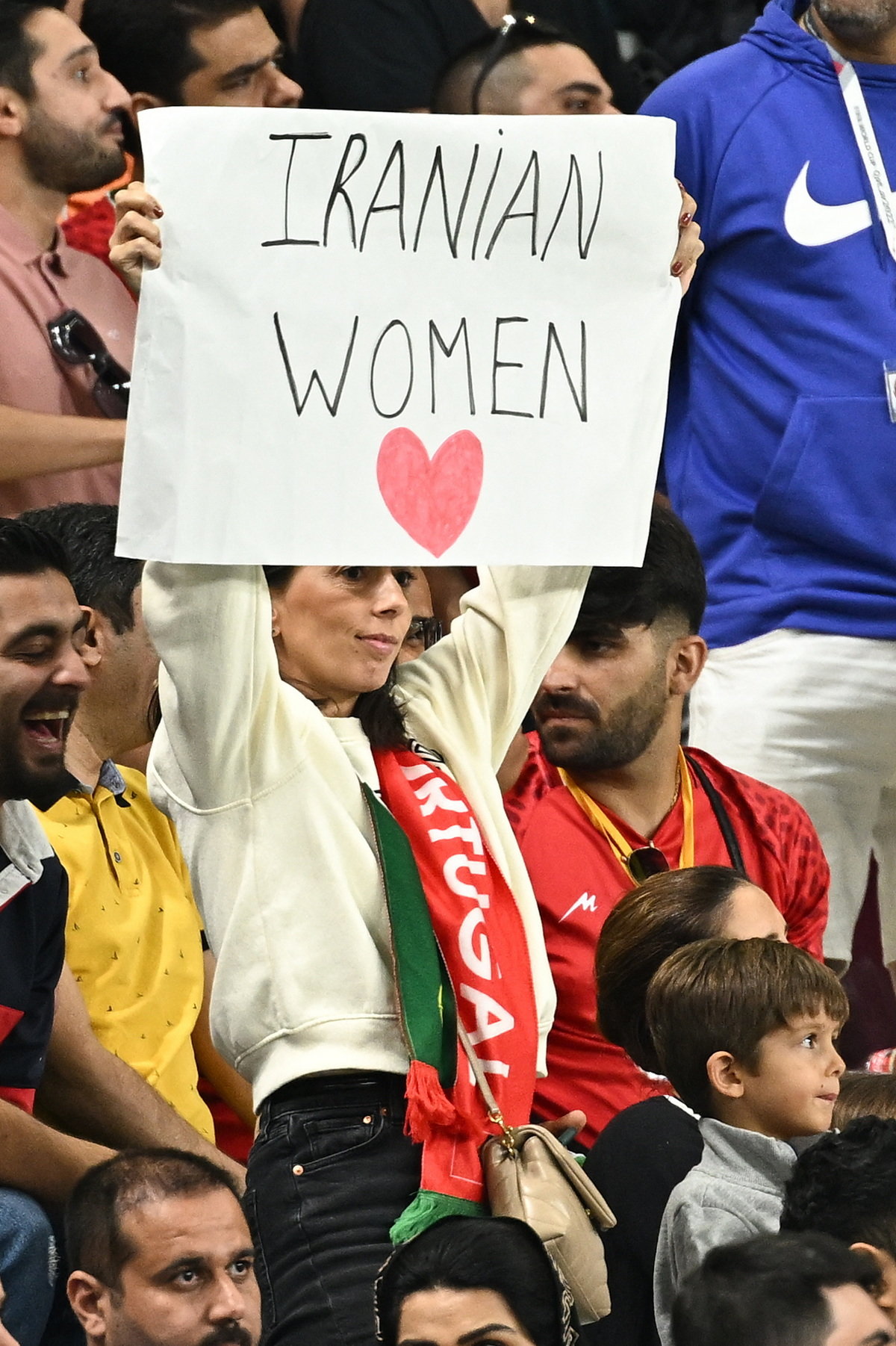 比赛现场，伊朗女球迷手举“伊朗妇女”的牌子。