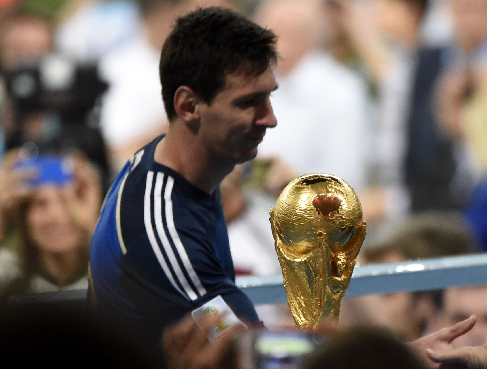 2014年7月13日，阿根廷队球员梅西在巴西世界杯颁奖仪式前从大力神杯前走过。