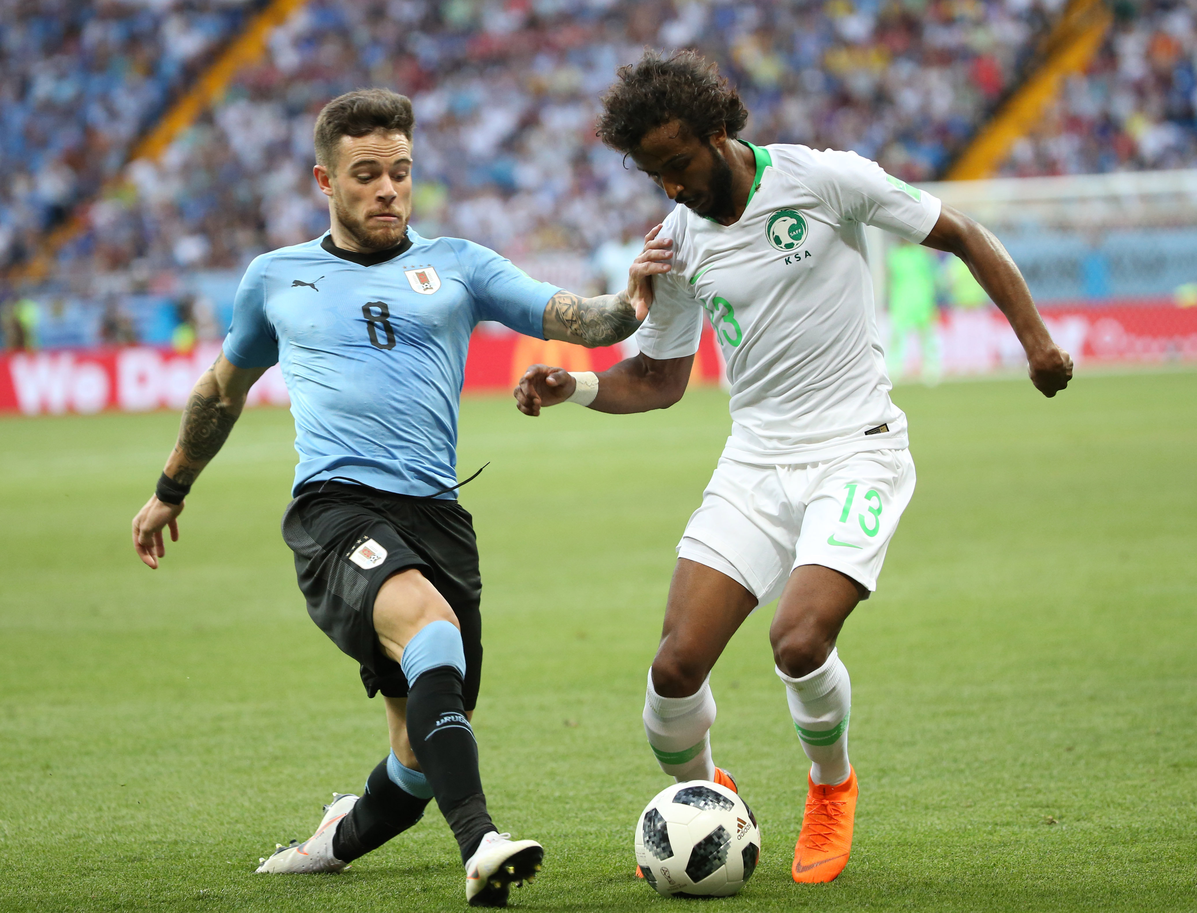 2018年6月20日，沙特阿拉伯队球员沙赫拉尼（右）与乌拉圭队球员在俄罗斯世界杯比赛中拼抢。
