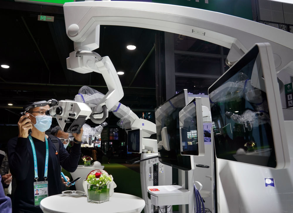 在第三届中国国际进口博览会医疗器械及医药保健展区蔡司集团展台，参观者体验手术显微镜（2020年11月6日摄）。新华社记者 刘颖 摄