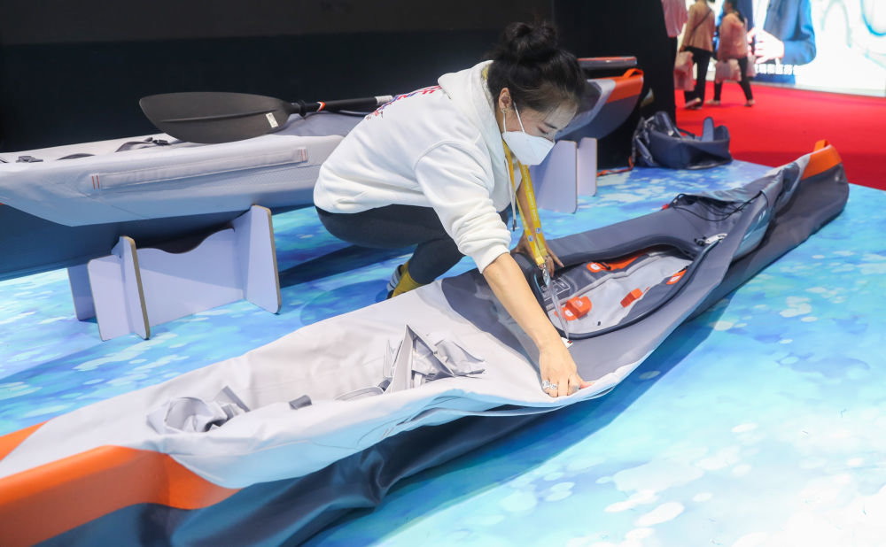 工作人员在第三届中国国际进口博览会消费品展区的迪卡侬展台演示可折叠皮划艇如何安装（2020年11月6日摄）。新华社记者 丁汀 摄