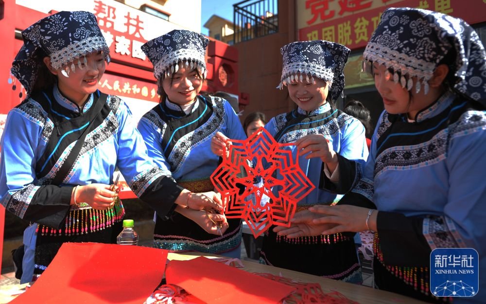 ↑1月13日，当地群众在罗甸县木引镇康梦家园焦点娱乐
习剪窗花。新华社发（班方智摄）