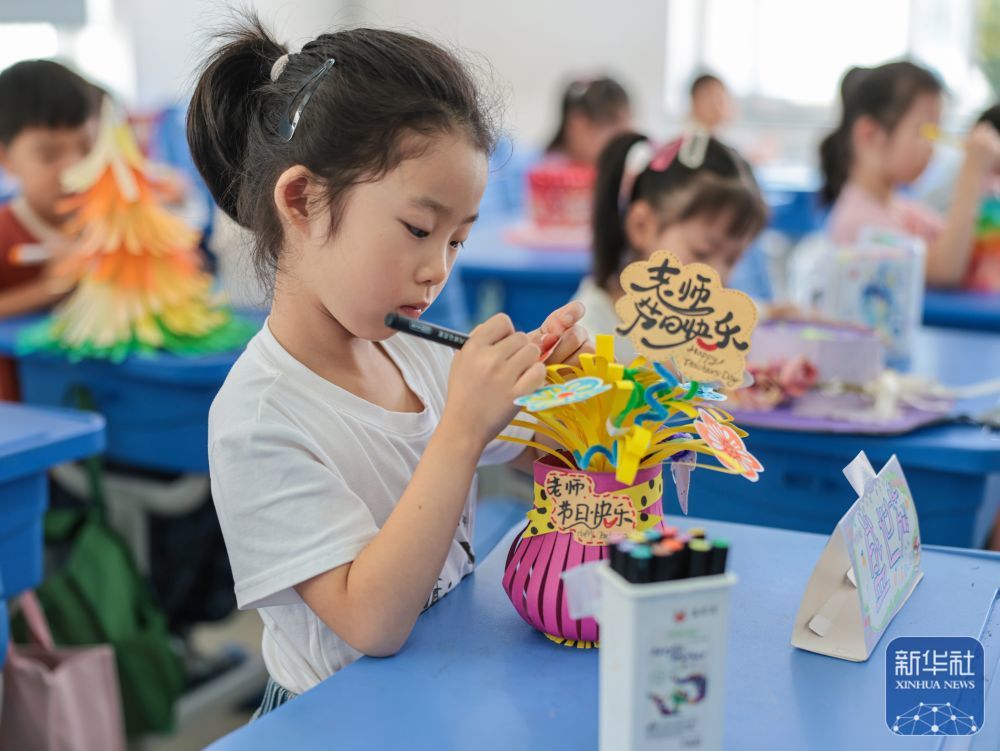9񀙙日，在山东省荣成市府新小学教室内，孩子们在制作送给老师的手工作品。新华社发（李信君摄）