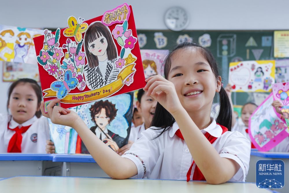 9񀙙日，在江苏省句容市实验小学，学生展示手工制作的教师节贺卡。新华社发（钟学满摄）