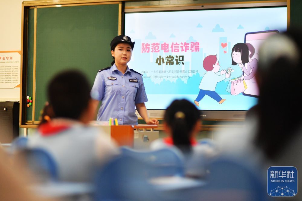 9月15日，在山东省青岛市市北区延安二路小学开展的网络安全教育主题活动上，民警为学生们讲解防范电信诈骗小常识。新华社发（王海滨摄）