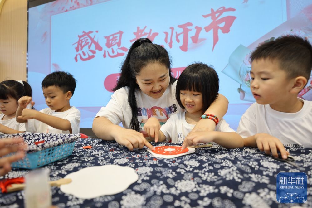9񀙙日，河南省开封市新街口幼儿园的小朋友们跟老师一起制作剪纸团扇。新华社发（石斐摄）