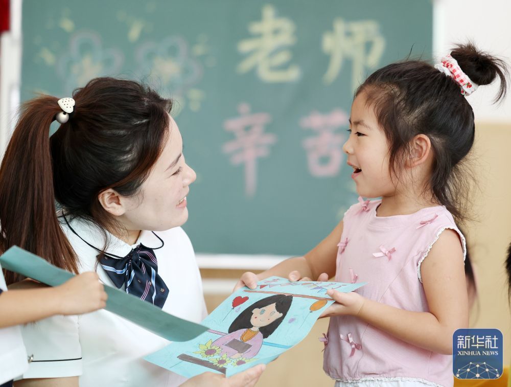 9񀙙日，山东省临沂市郯城县郯城街道官塘幼儿园的孩子将在老师的指导帮助下制作的绘画送给老师。新华社发（张春雷摄）